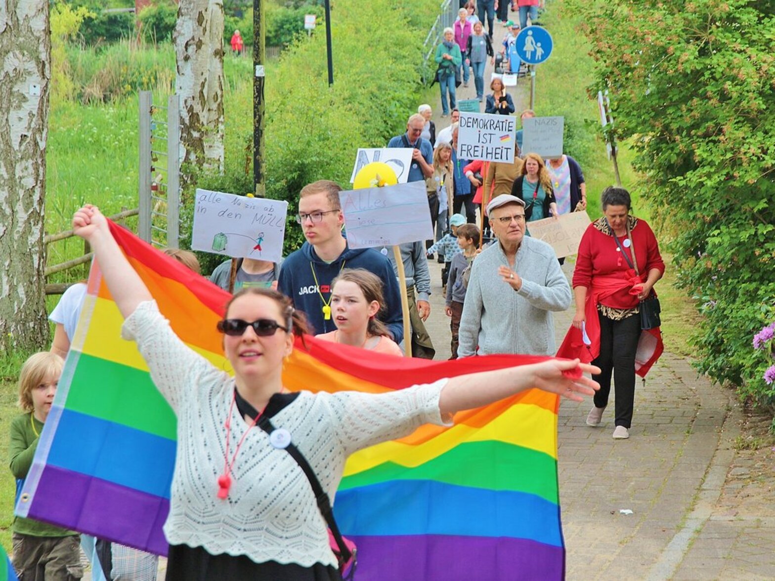 Menschen ziehen mit einer bunten Flagge umher