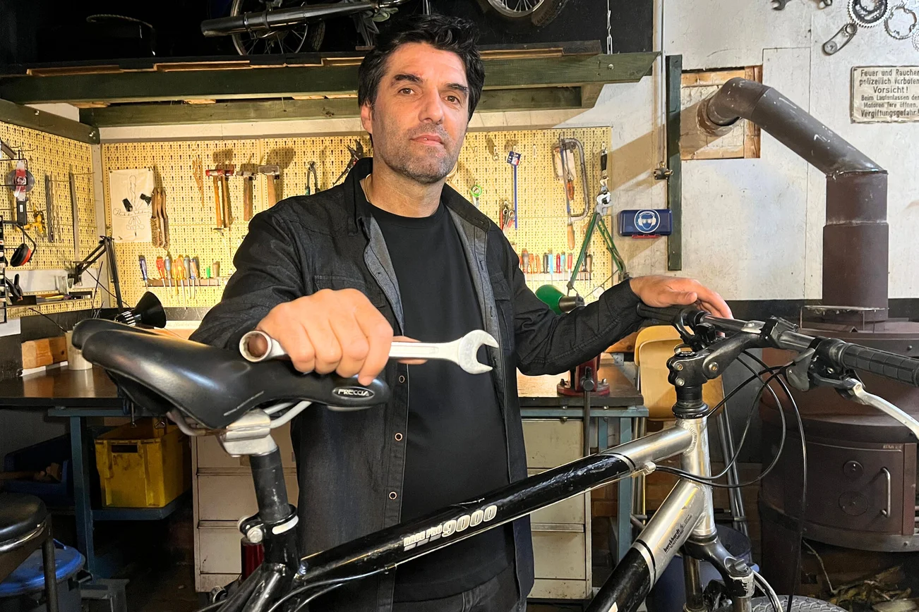 Mann steht an einem Fahrrad