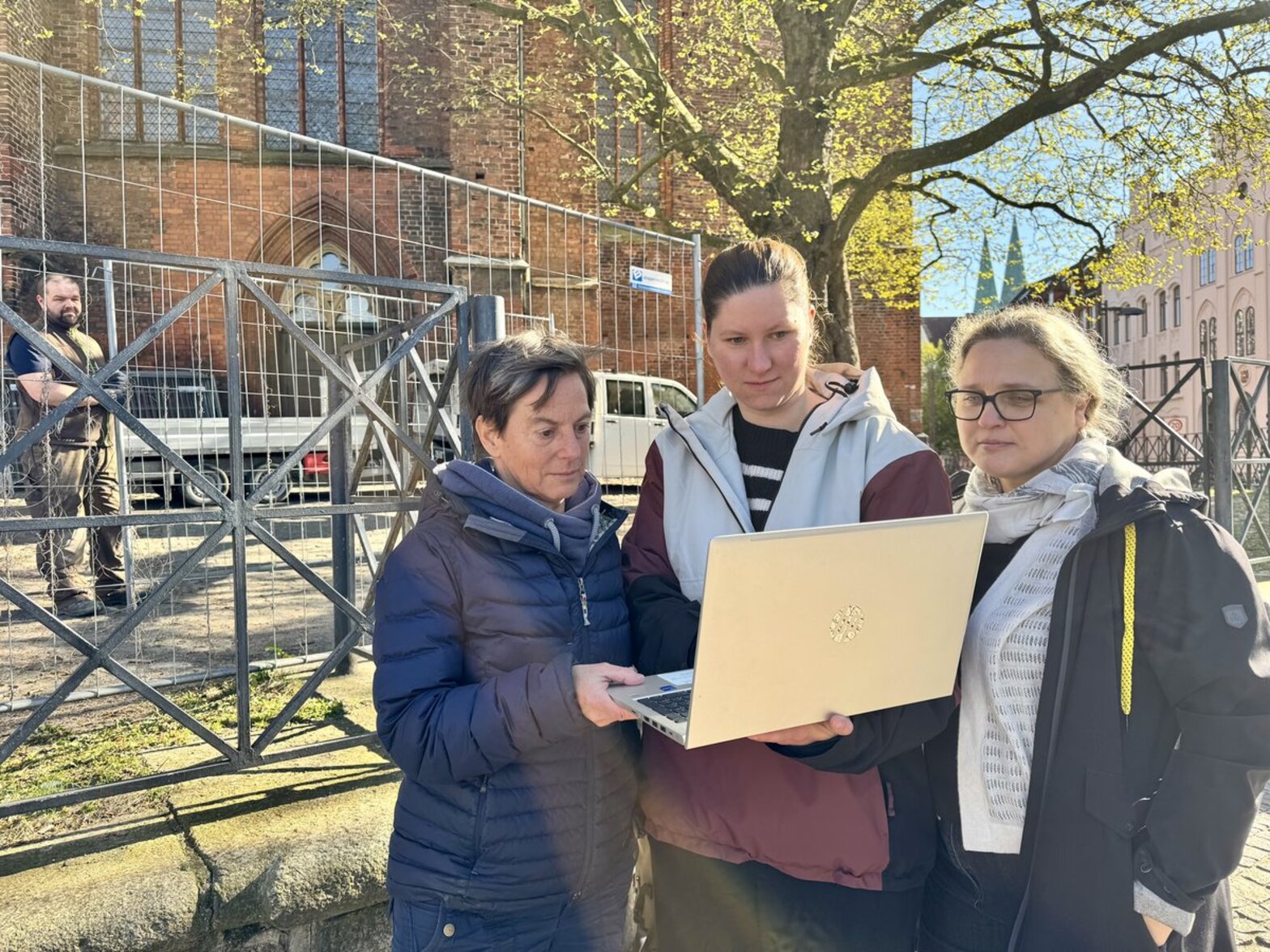 Drei Frauen stehen vor einer Kirche