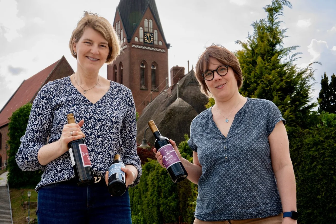 Zwei Menschen mit Flaschen vor einer Kirche 