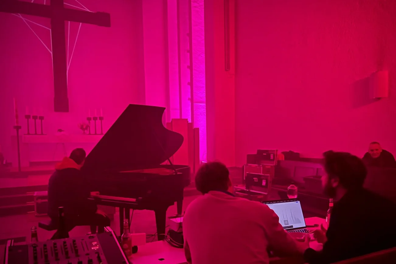 Ein Flügel steht in einem rot erleuchteten Kirchenraum.