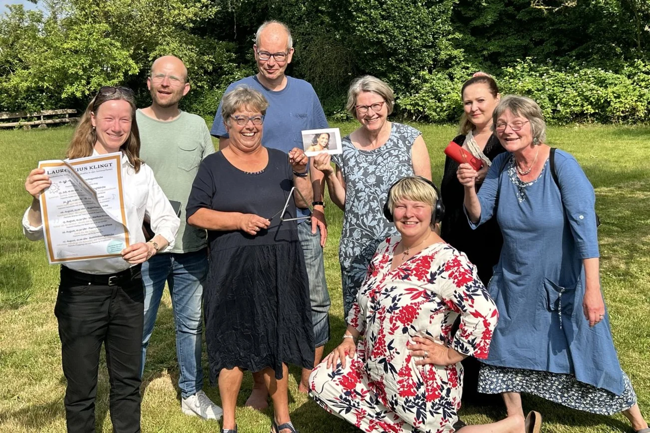 Ein Gruppe Menschen posiert fröhlich für die Kamera