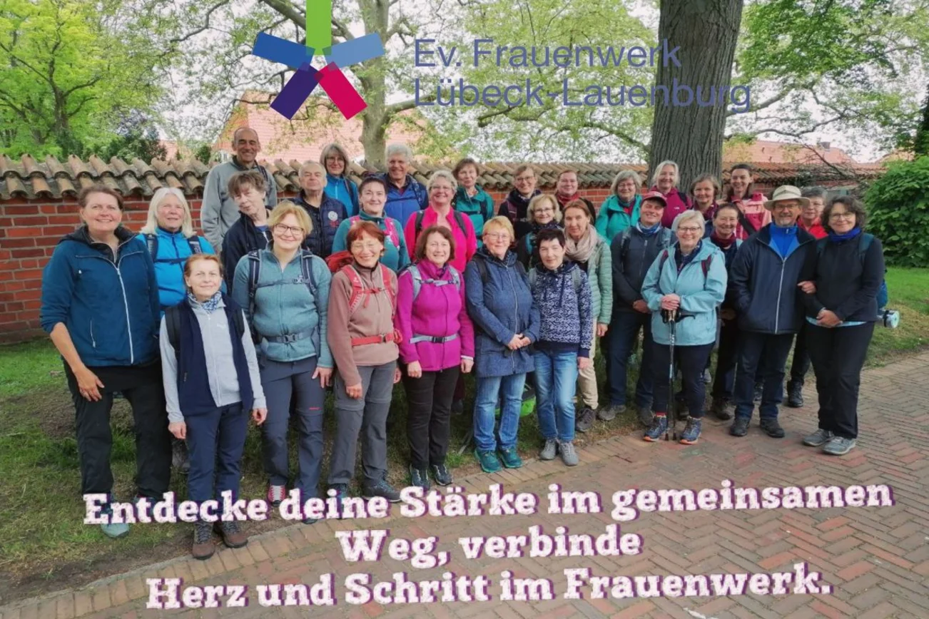 Eine Gruppe von Menschen steht vor einer Mauer