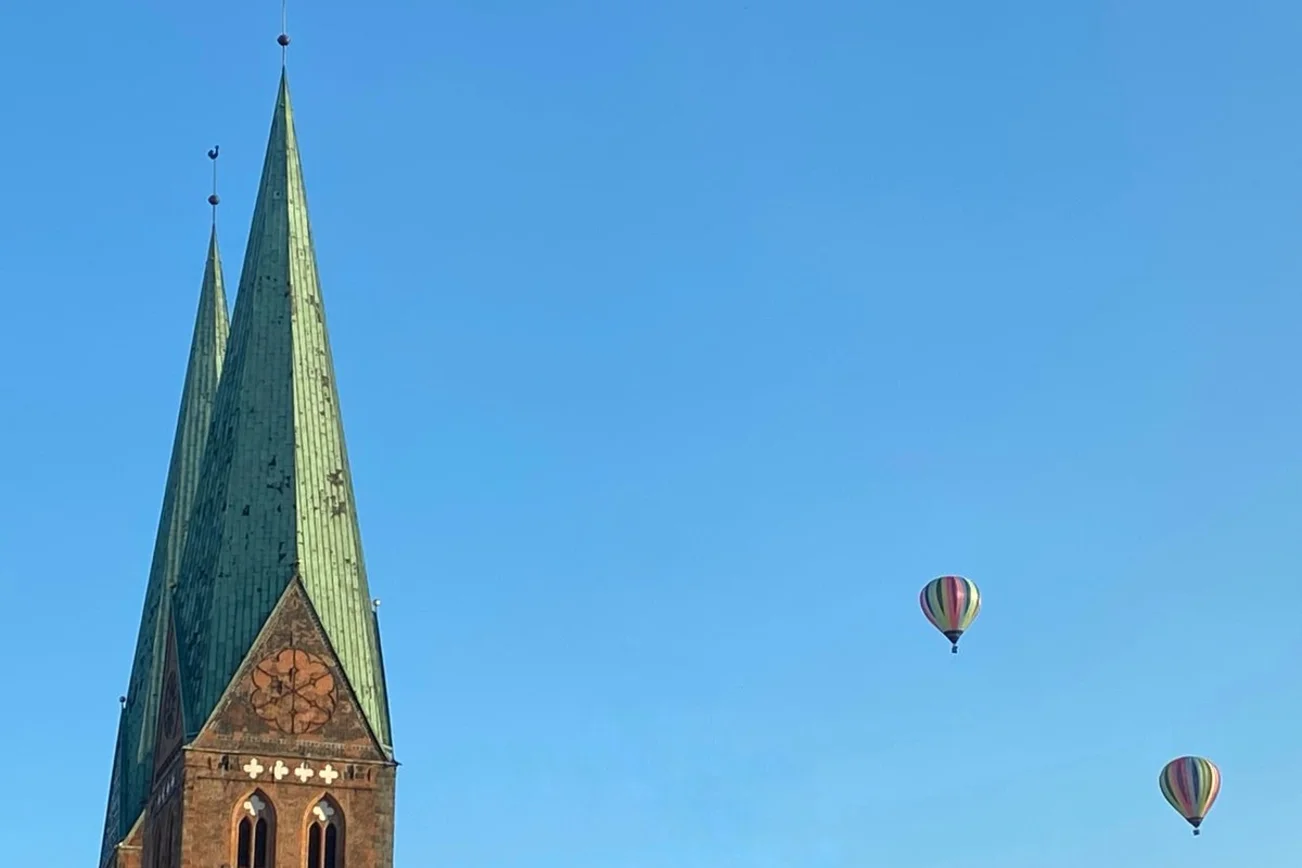 Turn einer Kirche mit zwei Heißluftballons