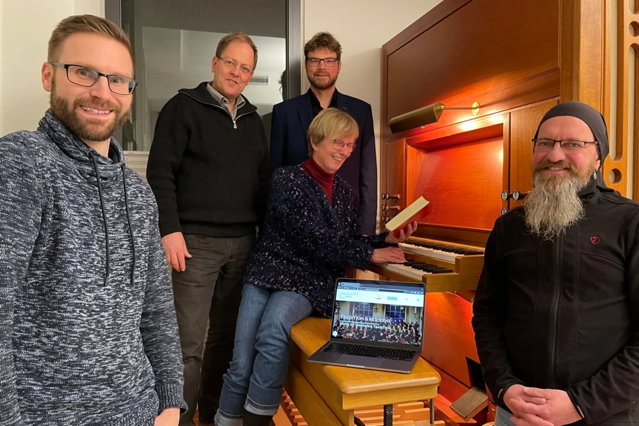 Fünf Menschen an einer Orgel.