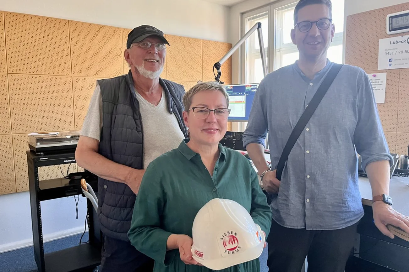 Drei Personen in einem Hörfunkstudio