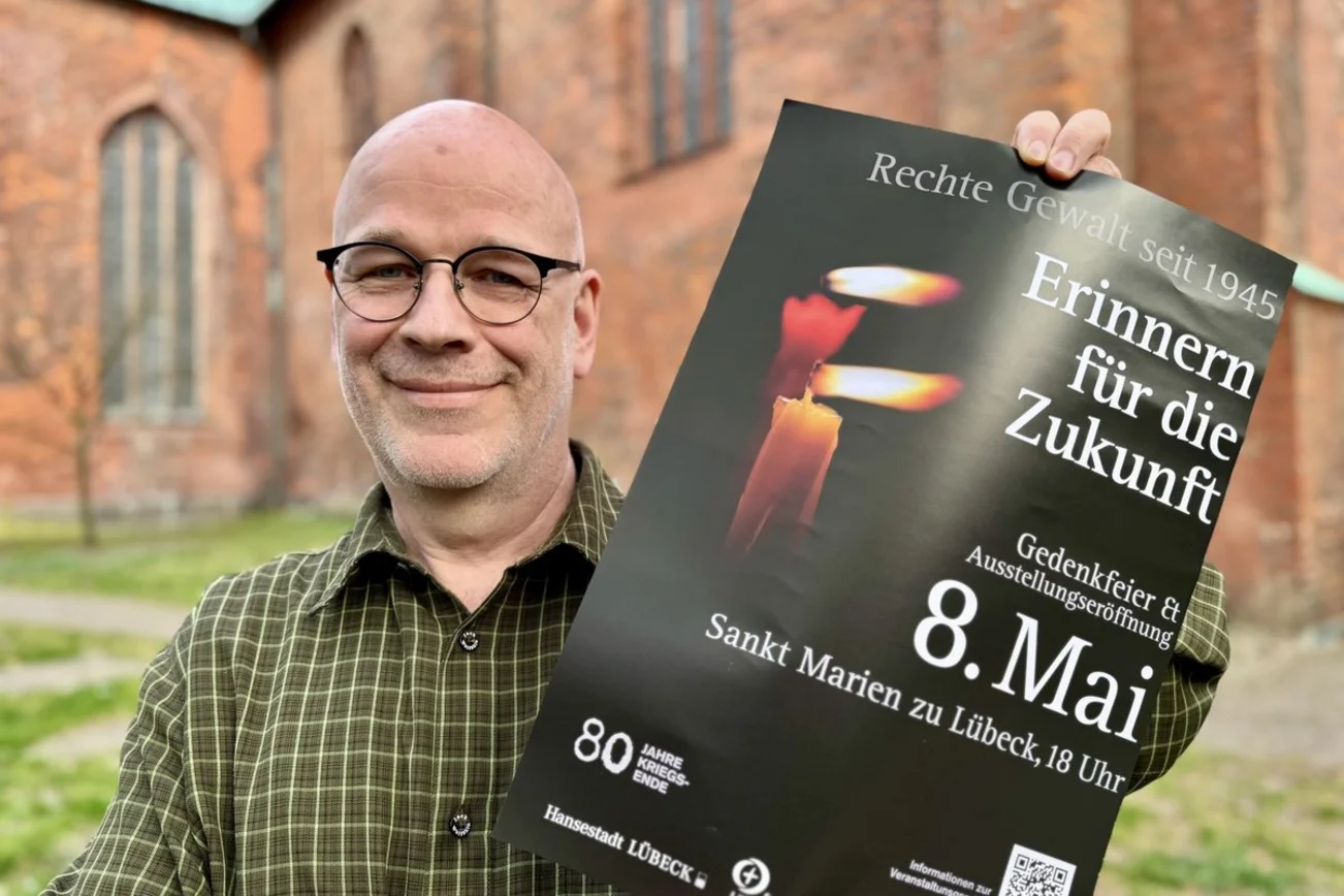 Ein Mann zeigt ein Plakat