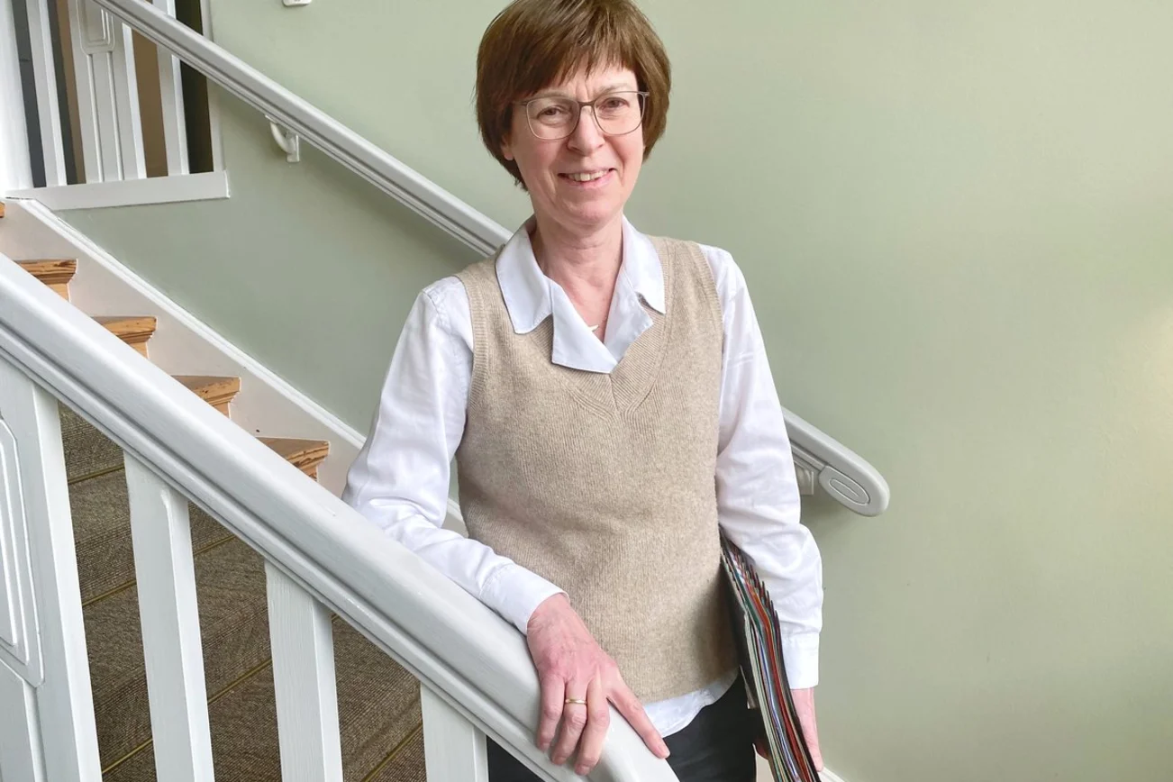 Eine Frau steht an einer Treppe.