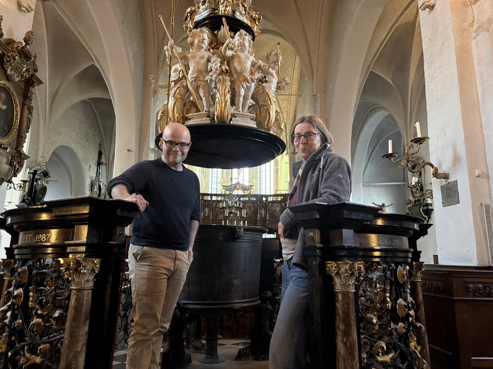 Ein Mann und eine Frau stehen vor dem Altar in der Kirche