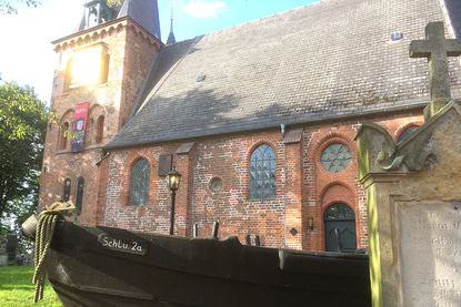 St.-Andreas-Kirche mit Fischerboot vor der Kirche - Copyright: Ev.-Luth. Kirchenkreis Lübeck-Lauenburg