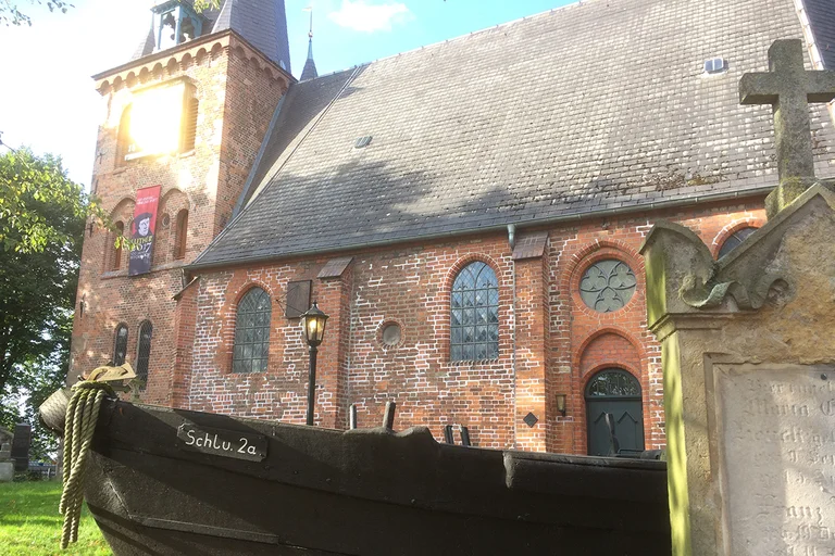 St.-Andreas-Kirche mit Fischerboot vor der Kirche