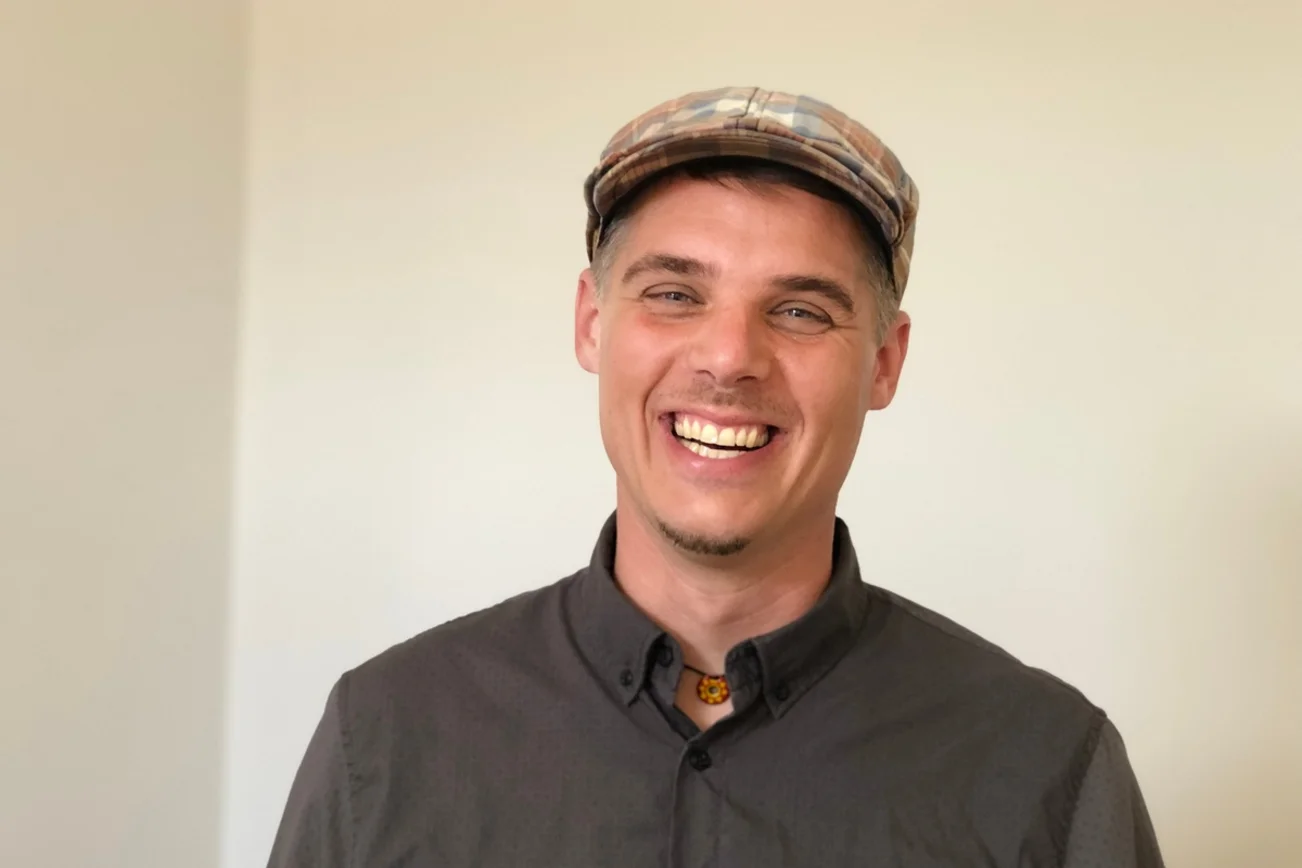 Mann, der den Betrachtenden anlächelt