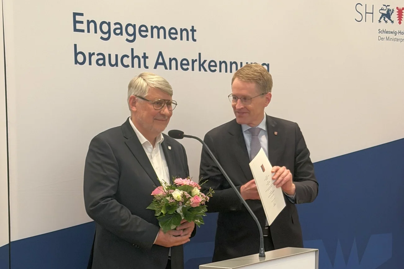 Zwei Männer stehen vor einem Mikrofon.