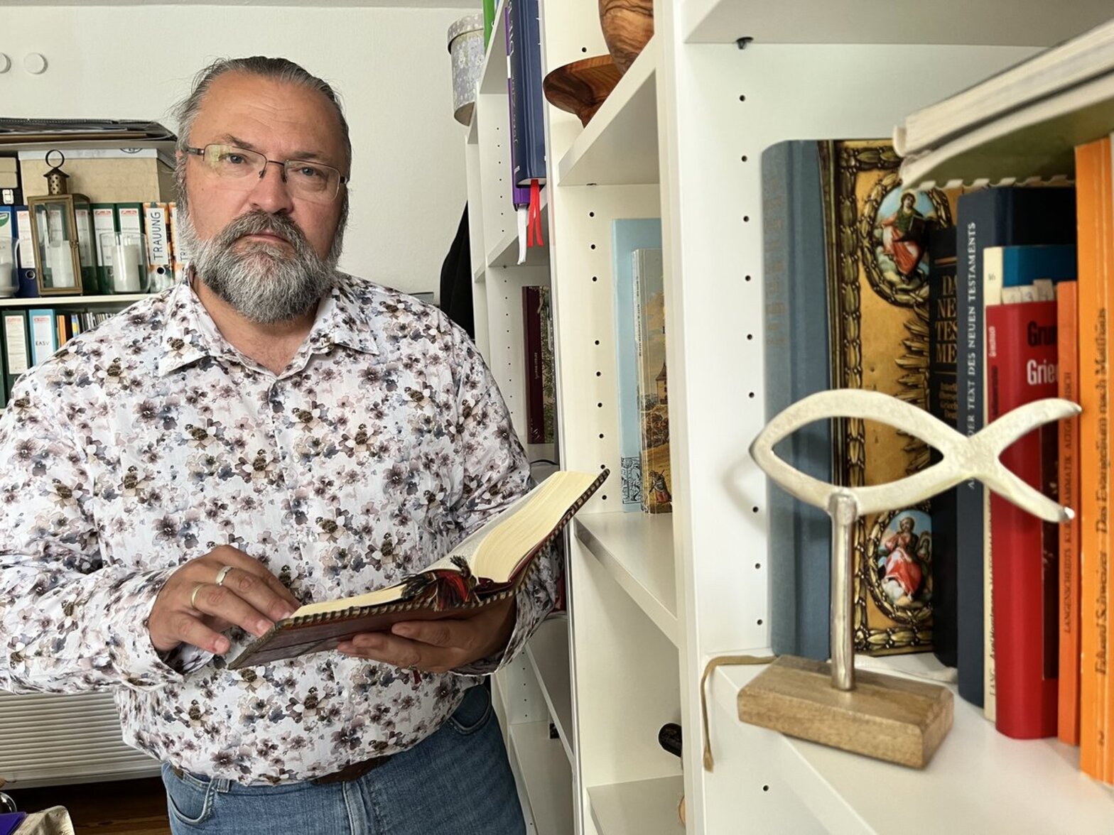 Ein Mann steht an einem Buchregal