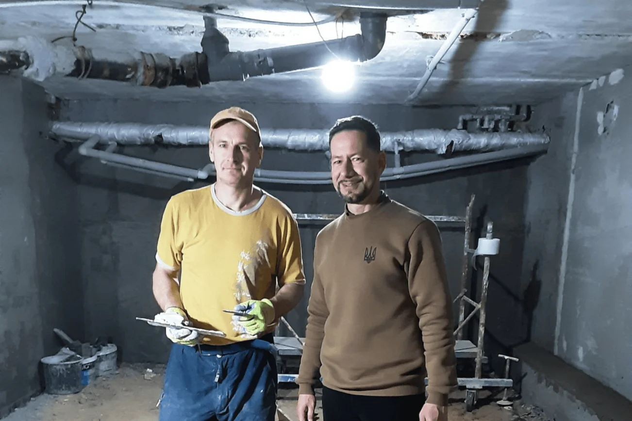 Zwei Männer stehen in einem Raum mit Baustellen-Charakter