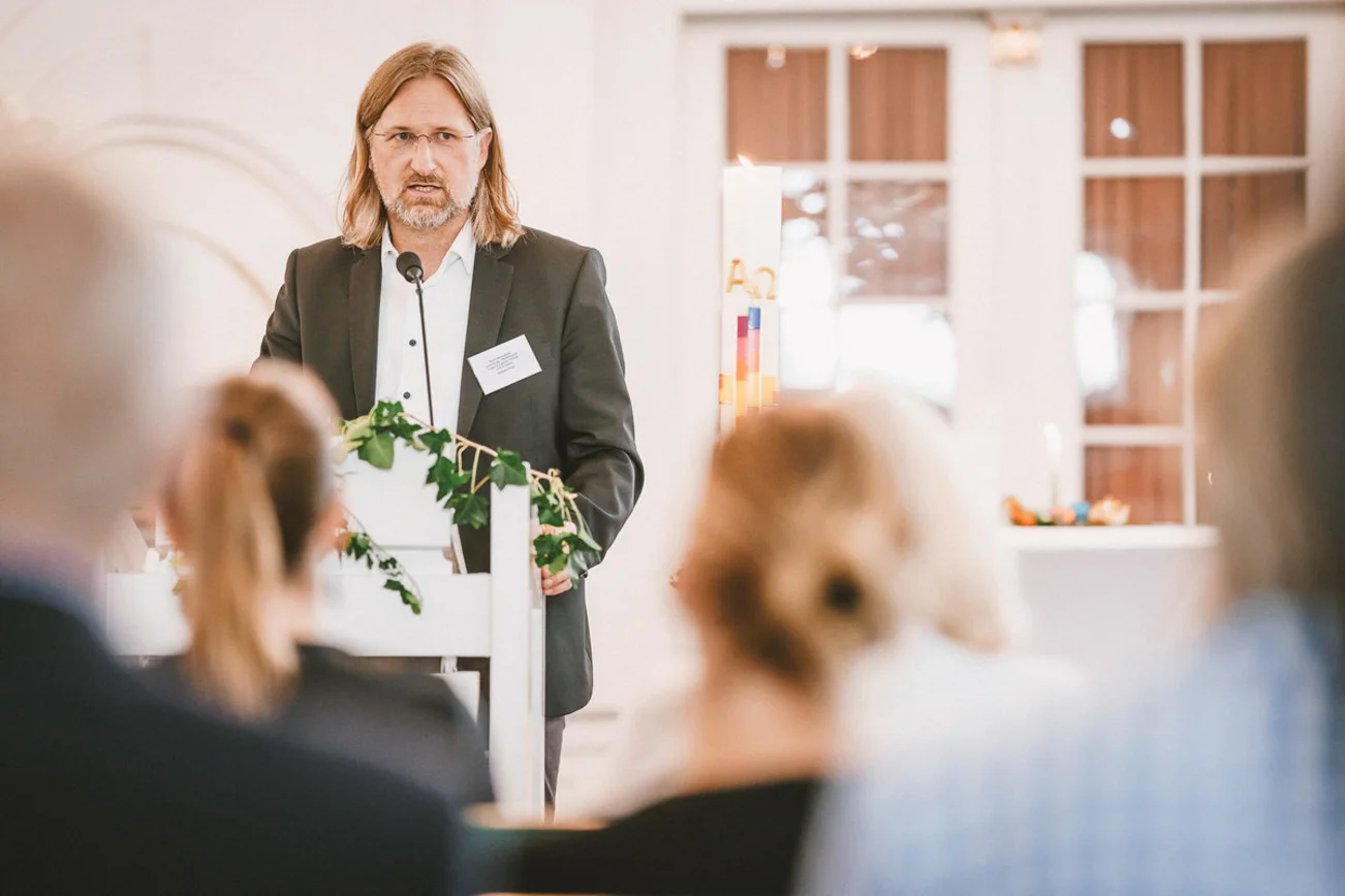 Ein Mann steht am Podium und hält eine Rede.