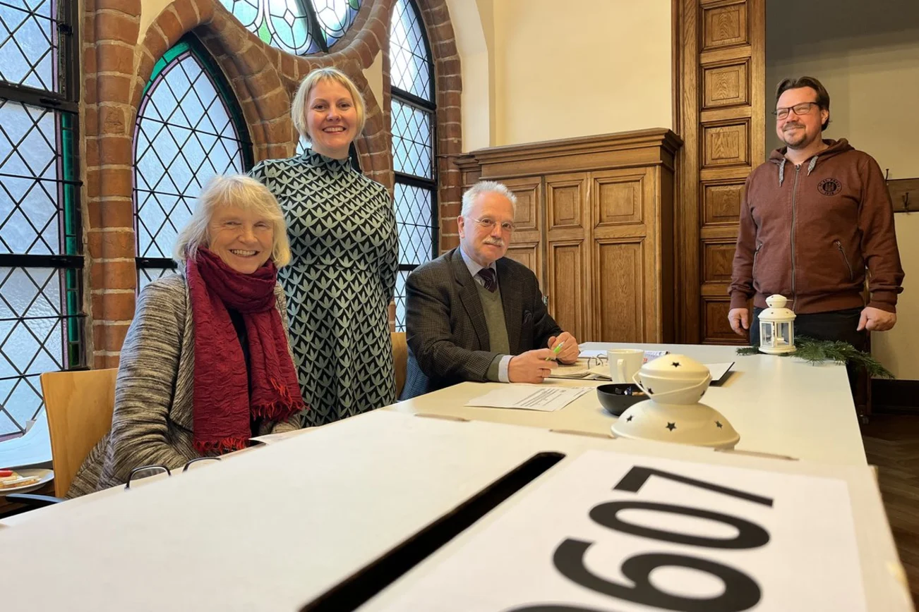 Drei Menschen in einem Wahlbüro