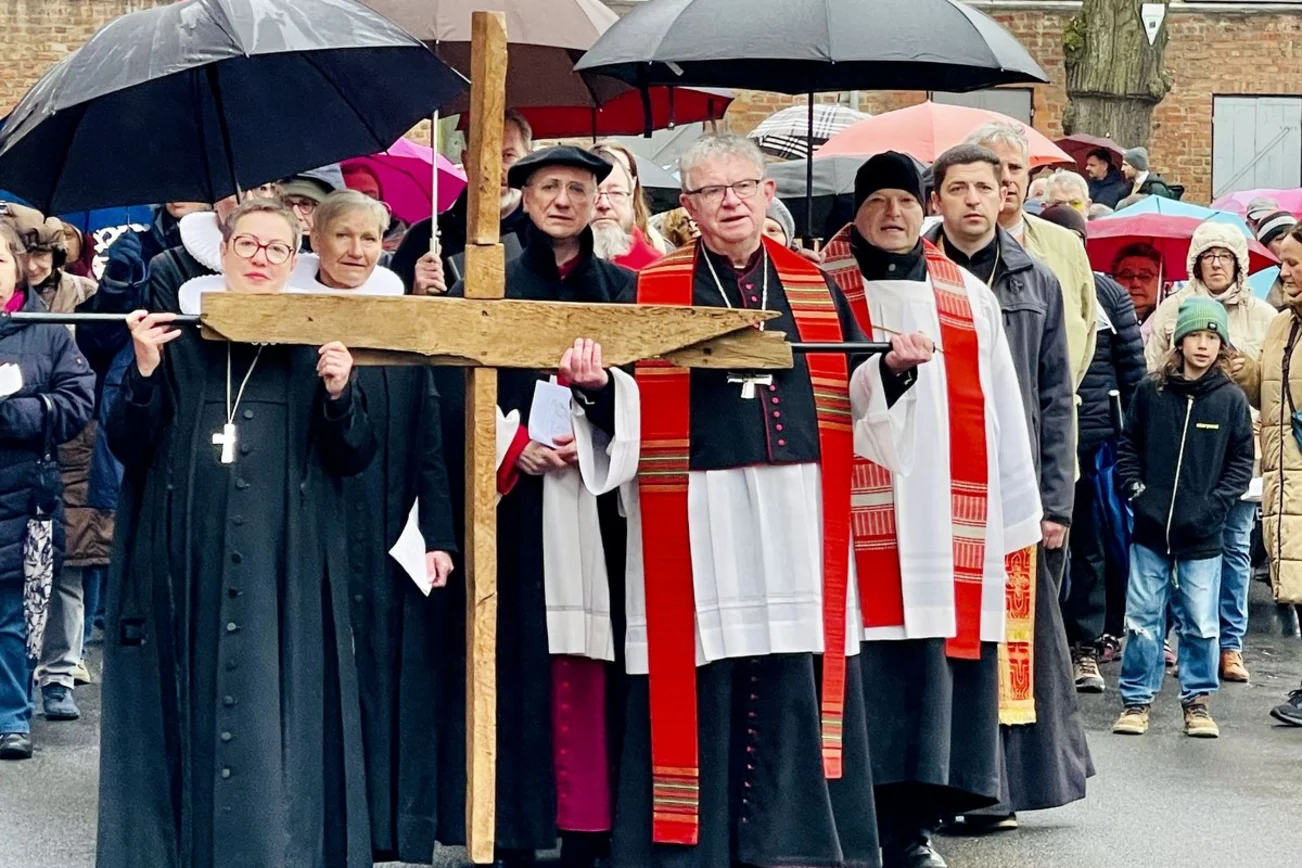 Menschen tragen ein Kreuz durch die Straße