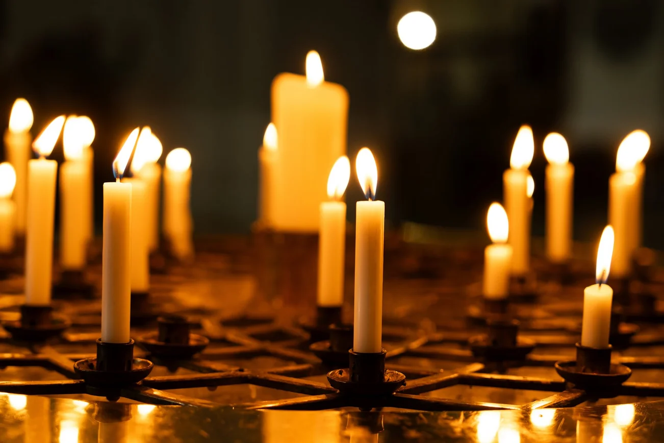 Mehrere brennende Kerzen im Dunkeln.