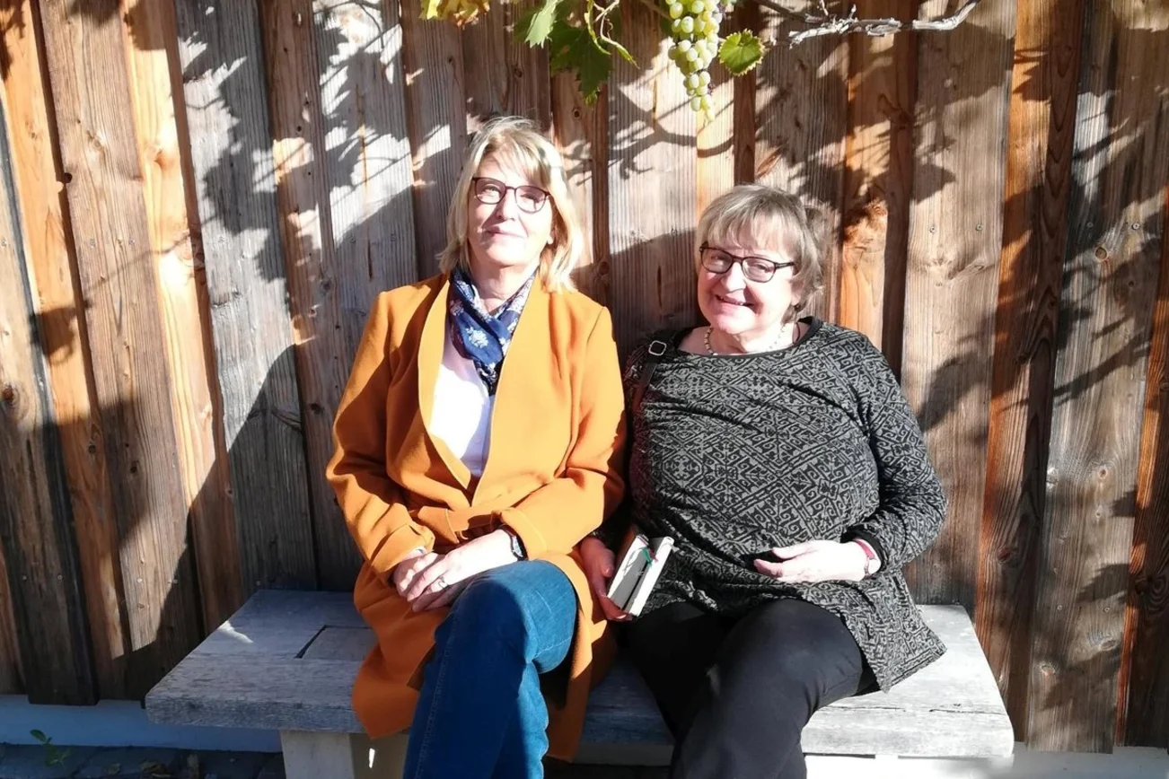 Zwei Frauen sitzen auf einer Bank