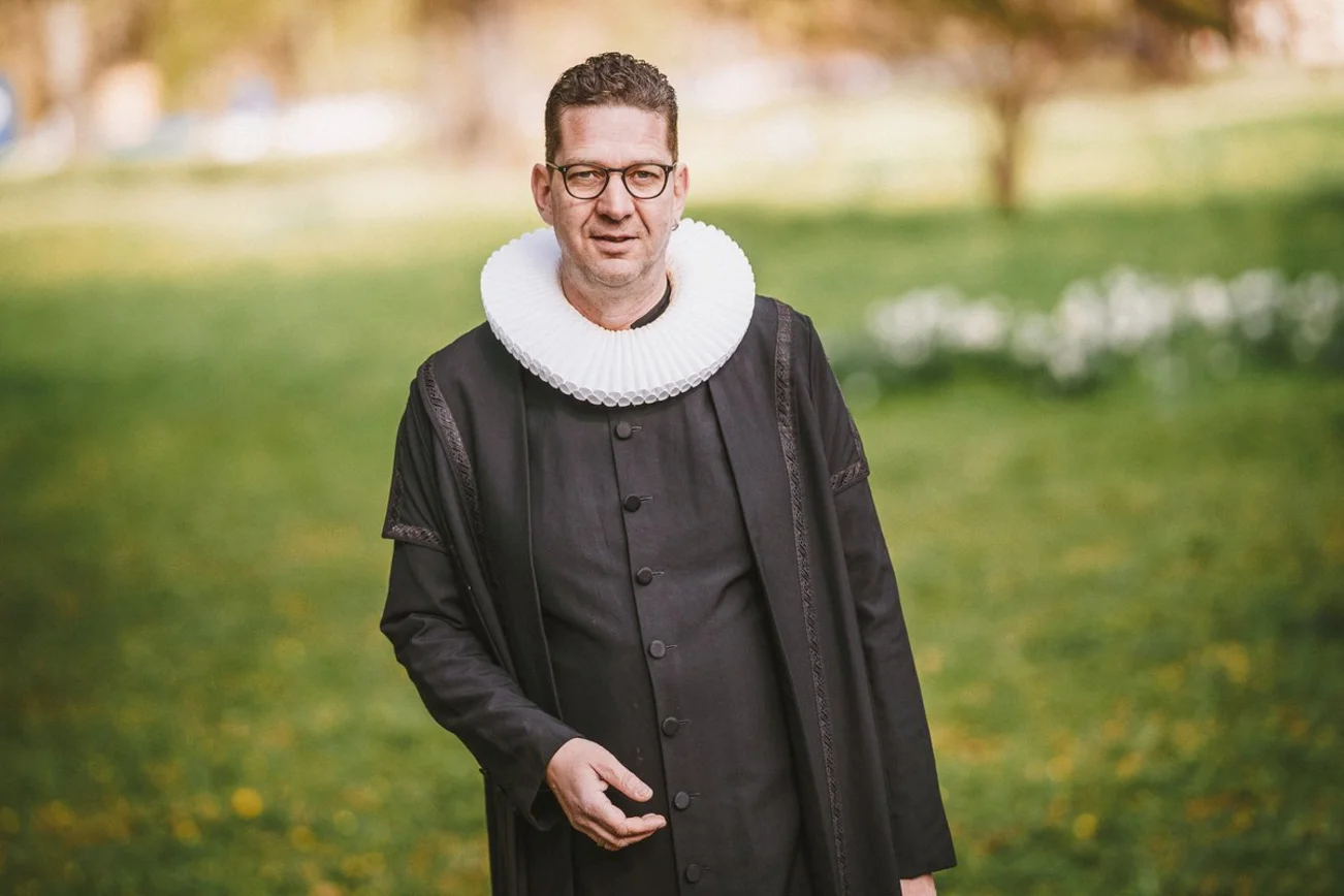 Ein Mann steht auf einer Wiese.