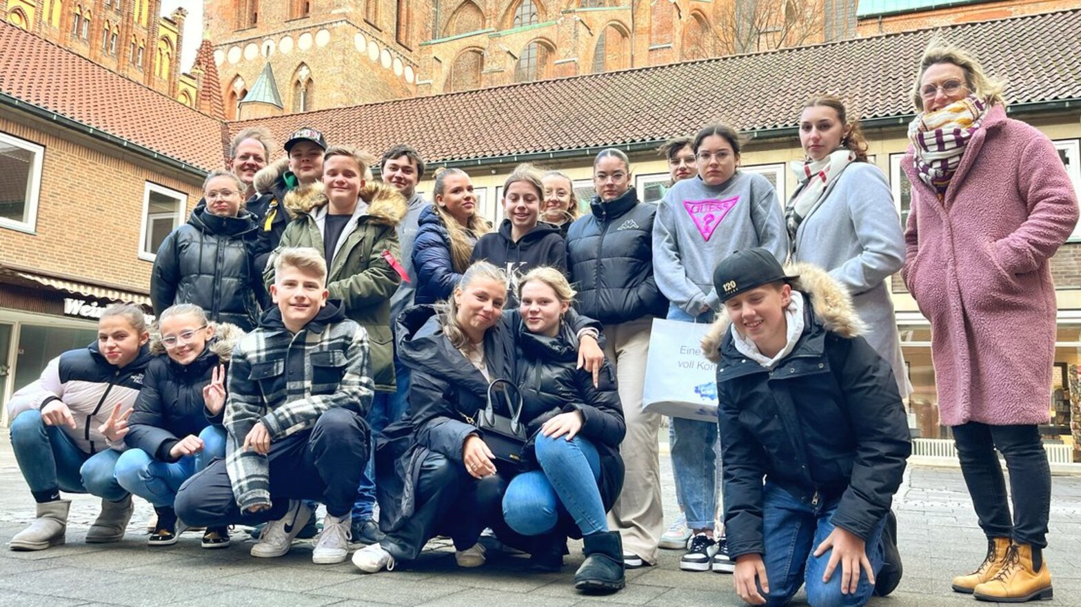 Jugendliche stehen zu einem Gruppenbild vor einer Kirche