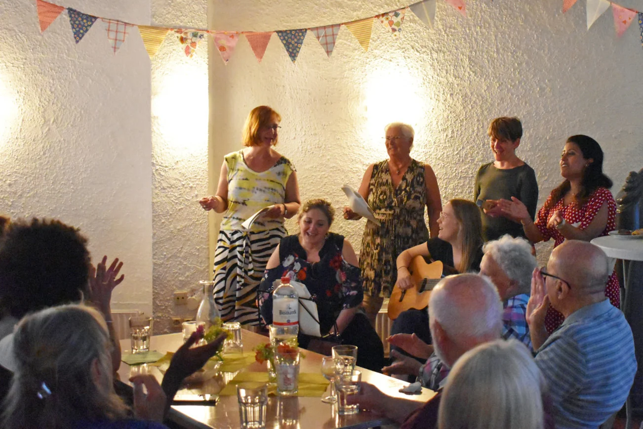 Viele Menschen feiern zusammen an einem Tisch.