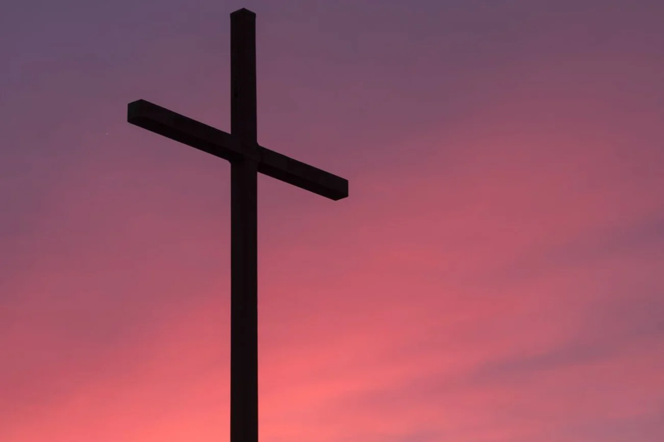 Kreuz vor einem violetten Himmel