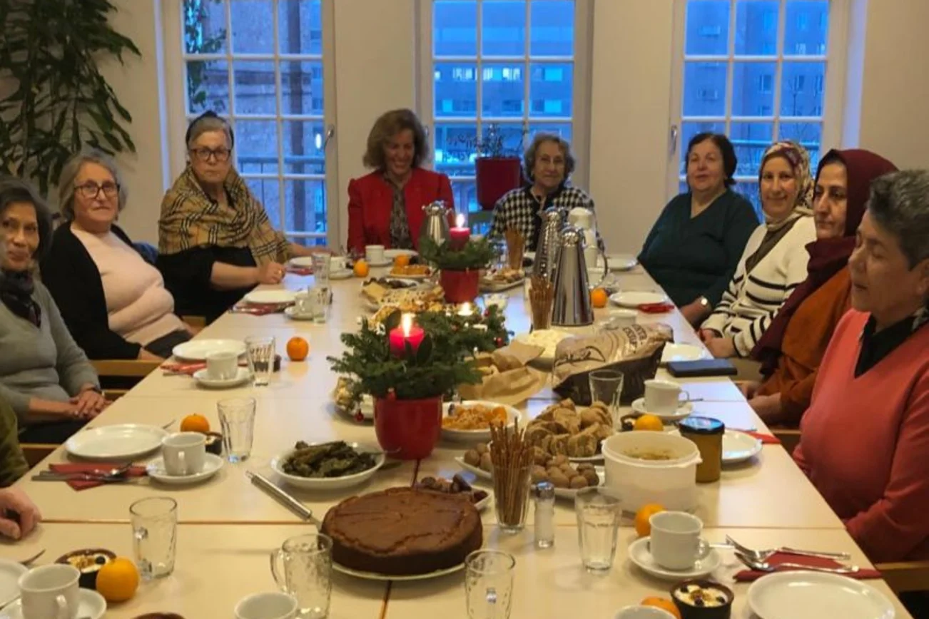 Frauen sitzen an einem reich gedeckten Tisch