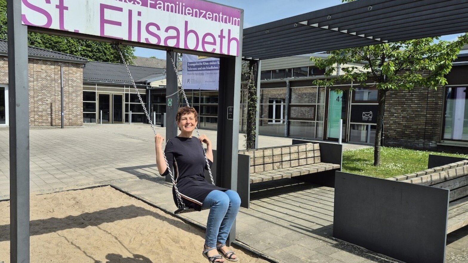 Pastorin Kühn auf einer Schaukel vor dem Familienzentrum Schwarzenbek