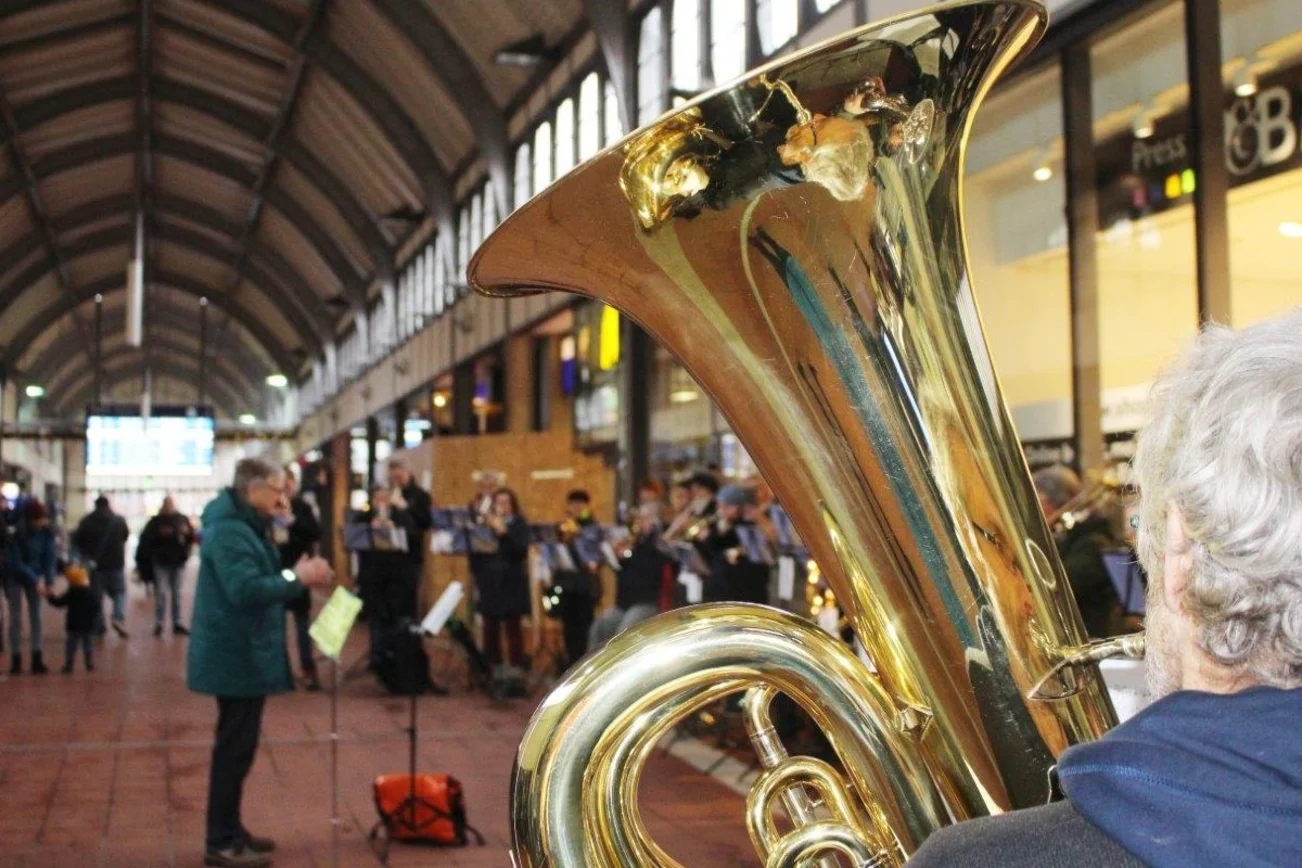 Ein Posaunenchor spielt in der Bahnhofshalle Lübeck