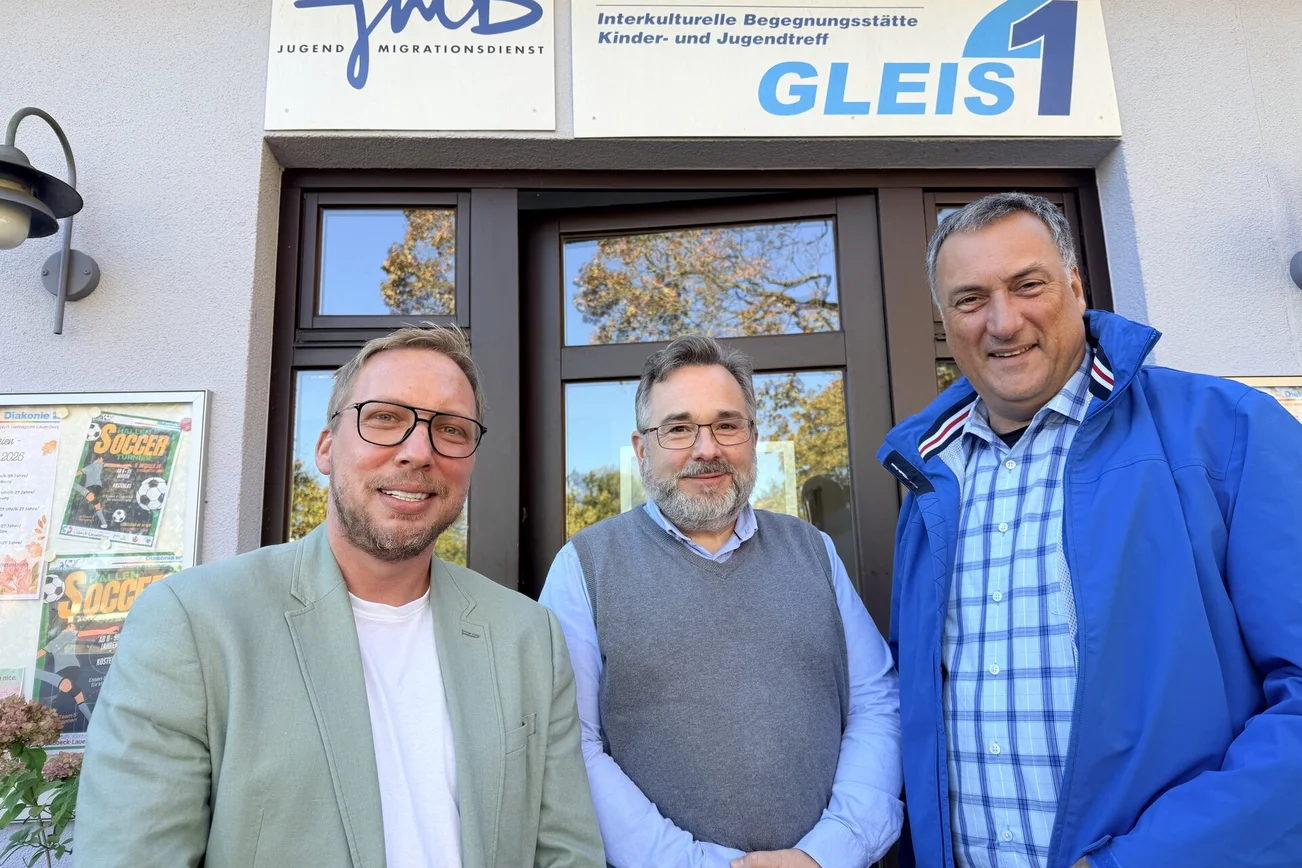Drei Männer vor einem Gebäude