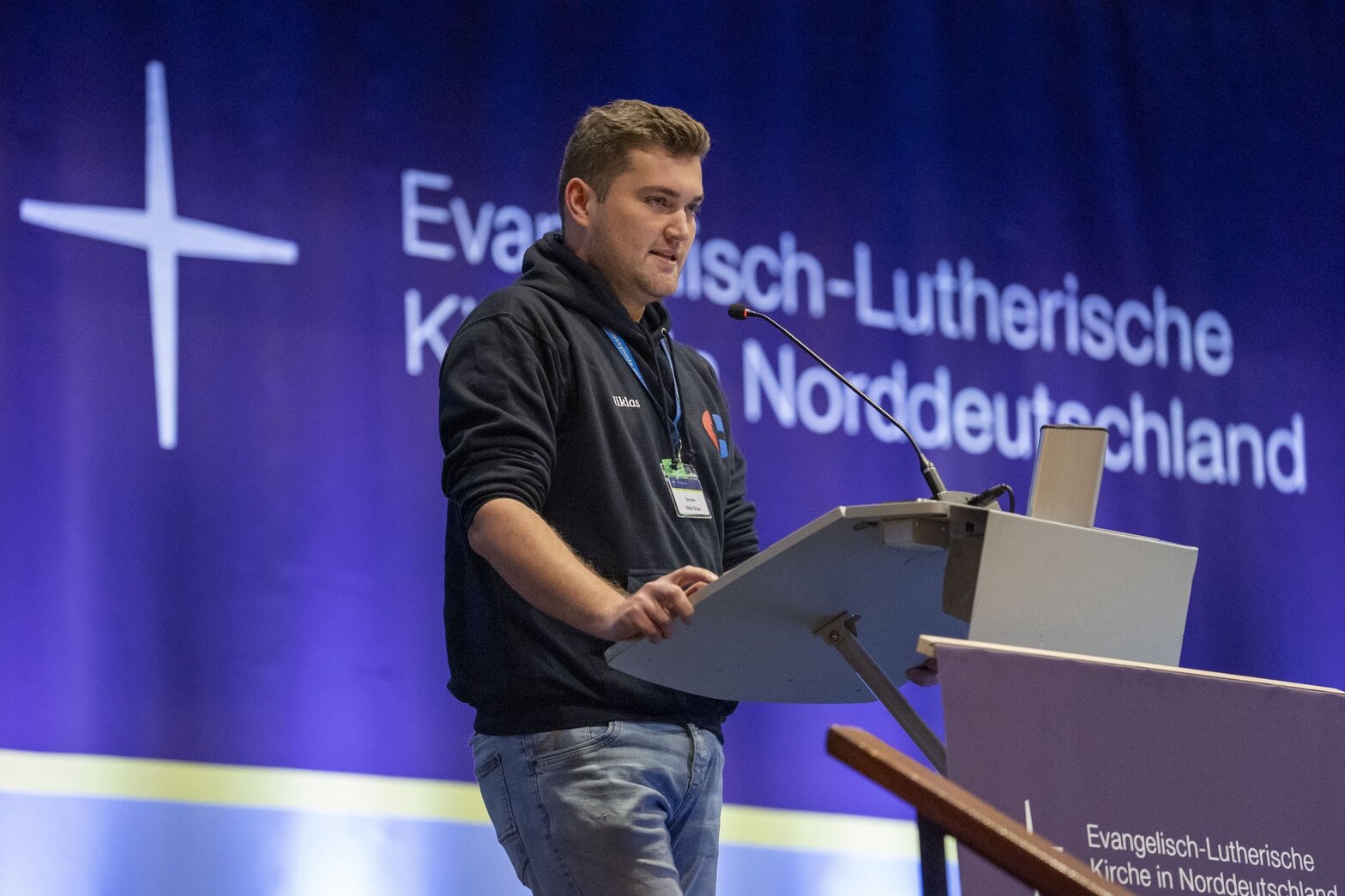 Ein Mann steht auf einer Bühne und spricht