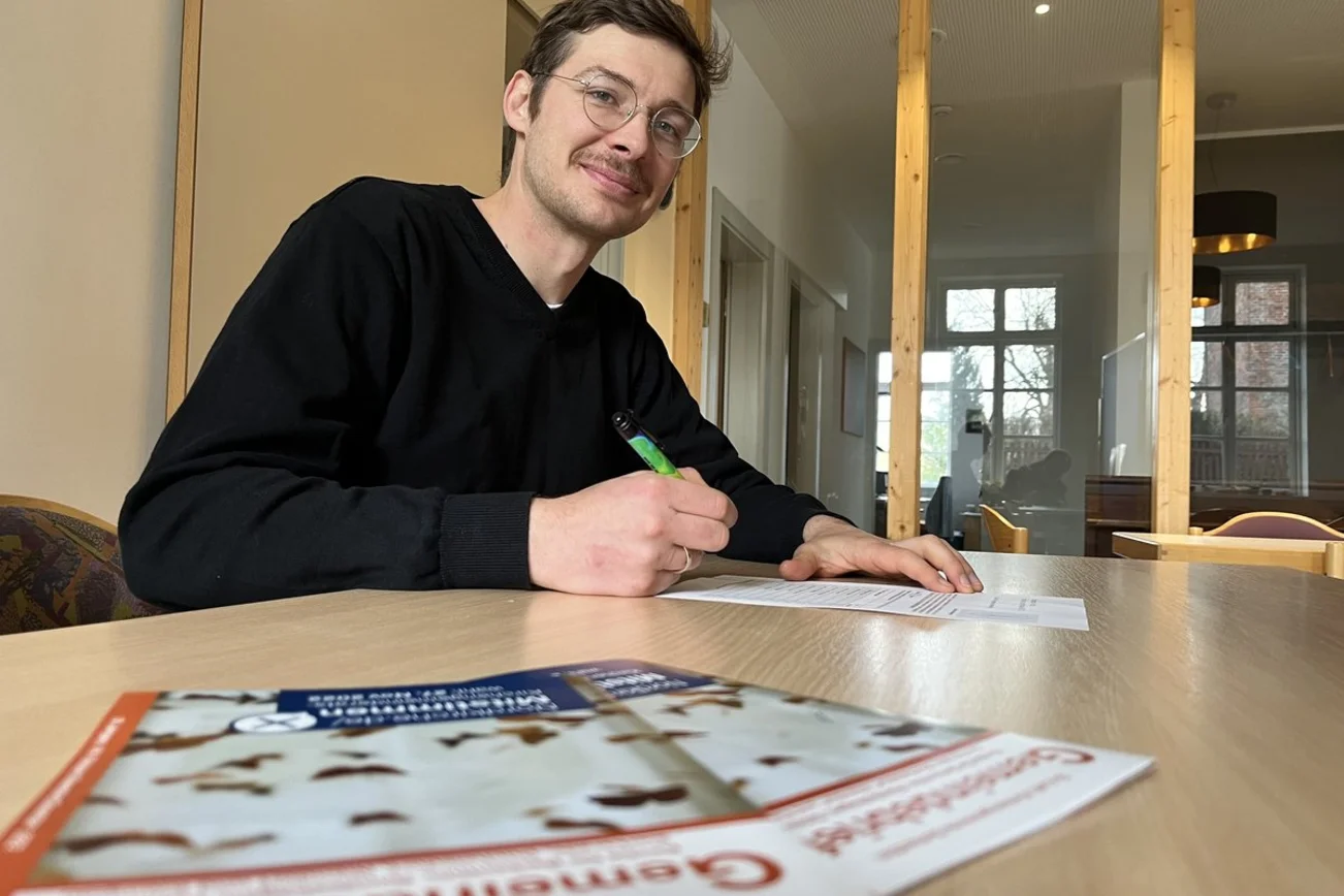 Ein Mann sitzt in einer Wahlkabine