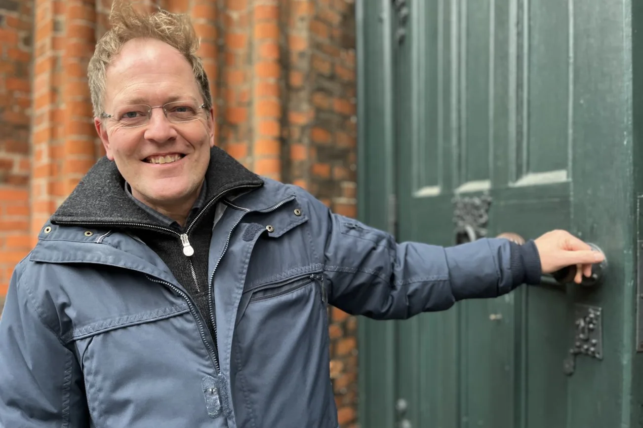 Ein Mann steht vor einer Kirche