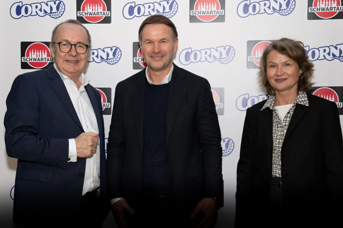 Drei Menschen lächeln in die Kamera