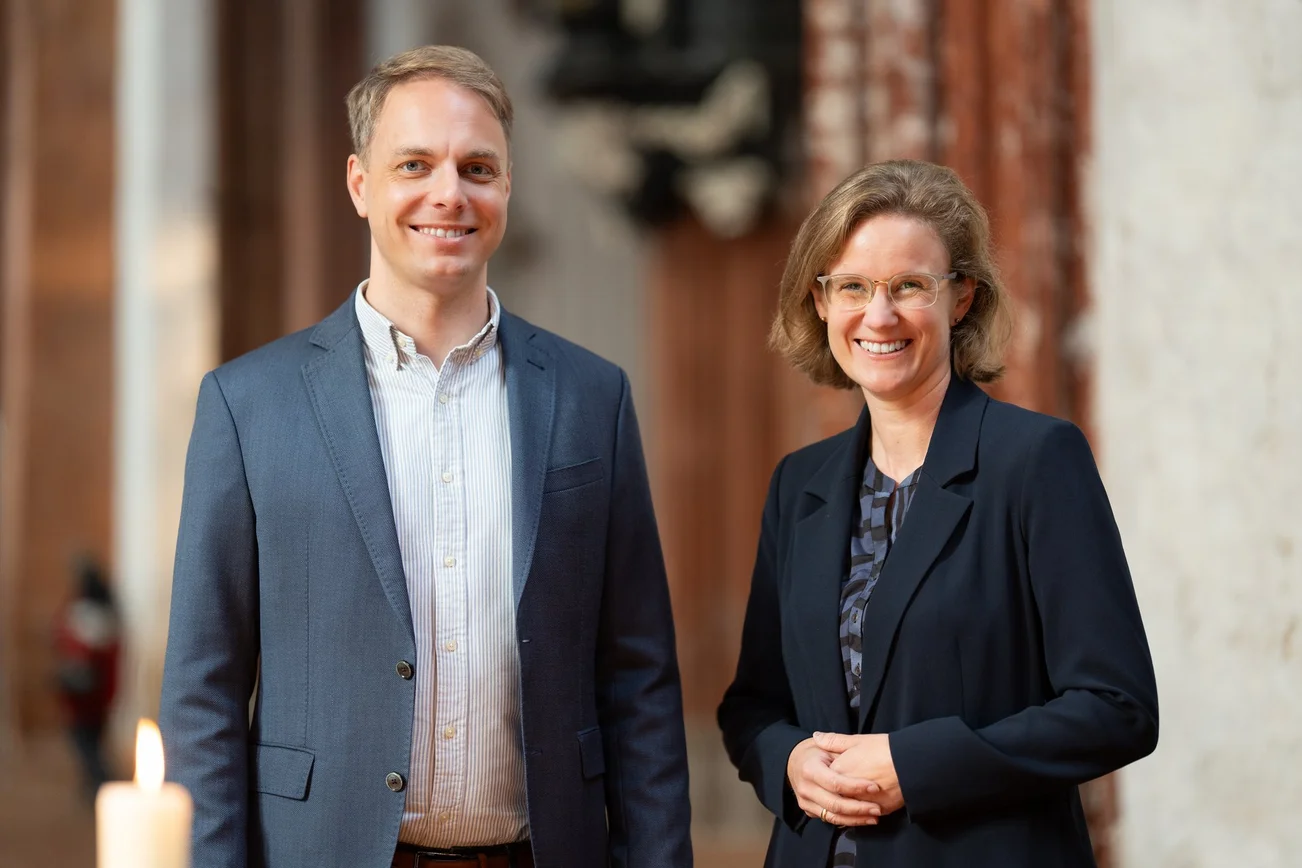 Zwei Personen lächeln in einer Kirche
