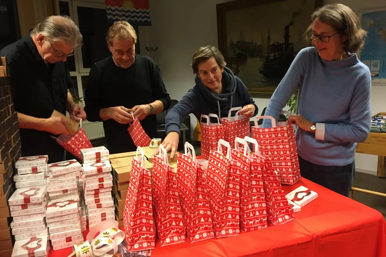 Vier Personen an einem Tisch mit Geschenken