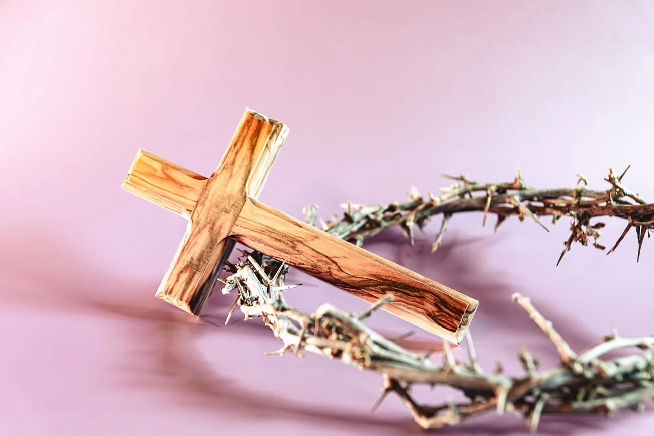 Ein Holzkreuz liegt auf einer Dornenkrone