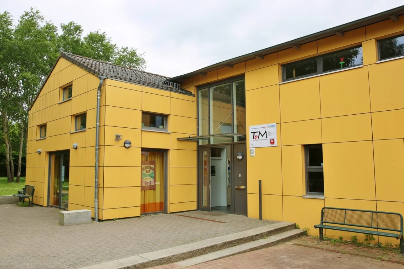 Ein gelbes Haus mit einem Schild mit der Aufschrift ToM