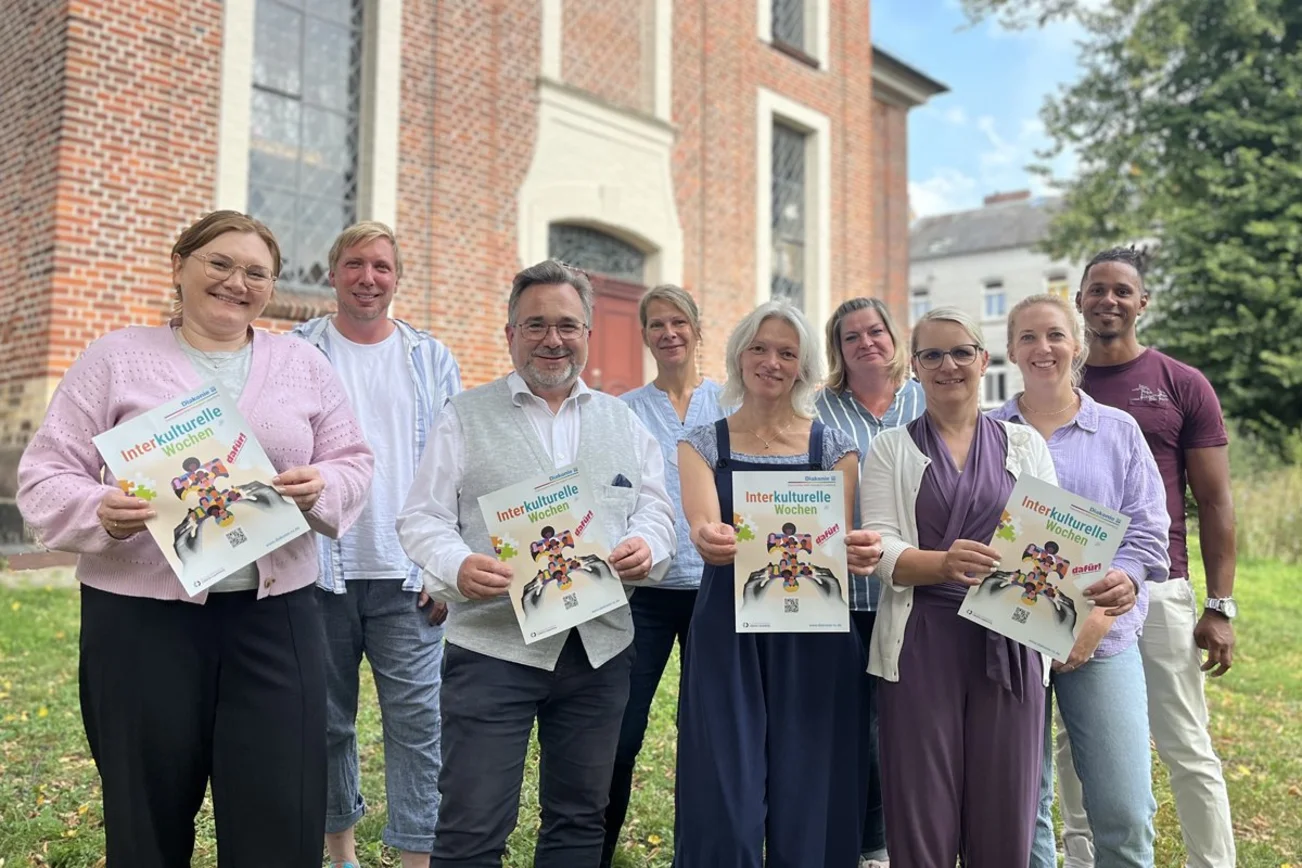 Gruppenfoto mit Frauen und Männern. Einige halten Plakate der Interkulturellen Wochen. 