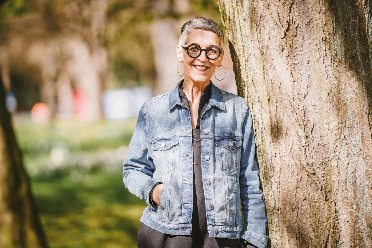 Lächelnde Frau an einem Baum gelehnt