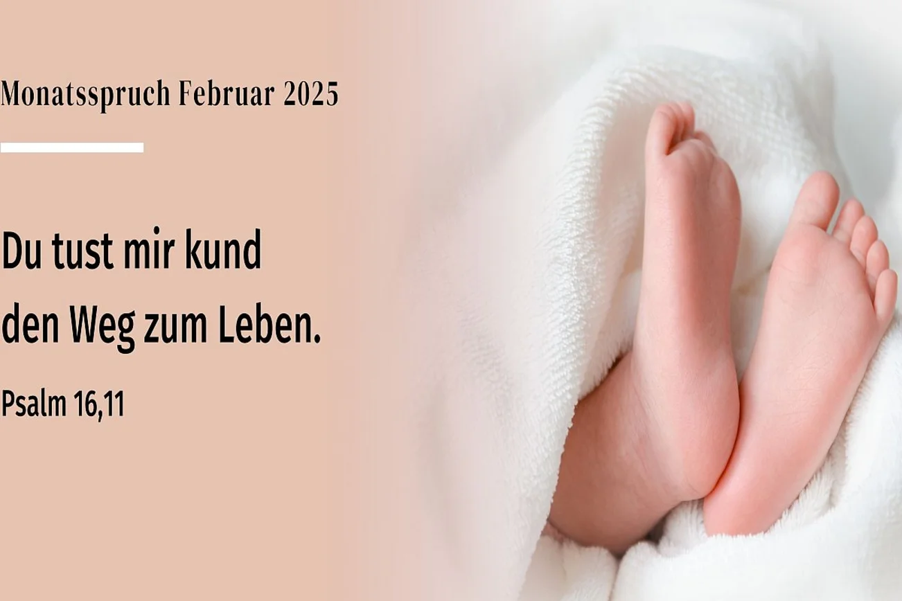 Zwei Babyfüße schauen aus einen weichen, weißen Decke heraus