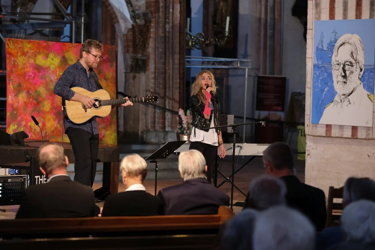 Ein Mann und eine Frau musizieren auf einer Bühne