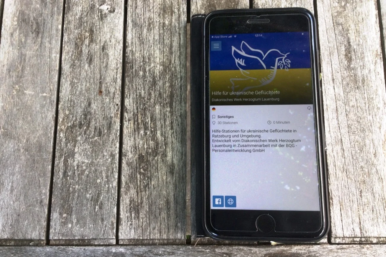 Ein Handy mit der Startseite der Willkommens-App für ukrainische Geflüchtete