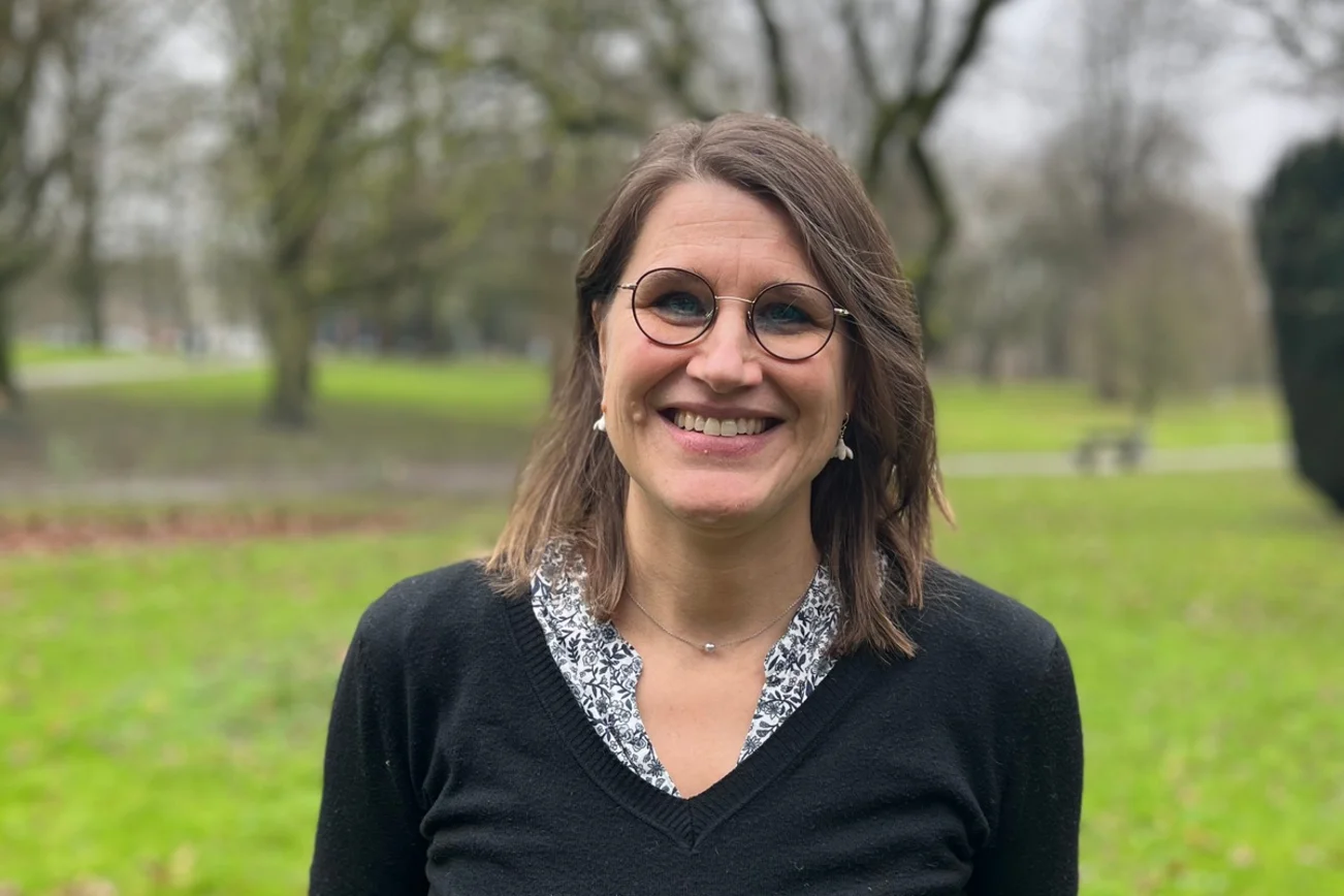 Frau schaut lächelnd in die Kamera