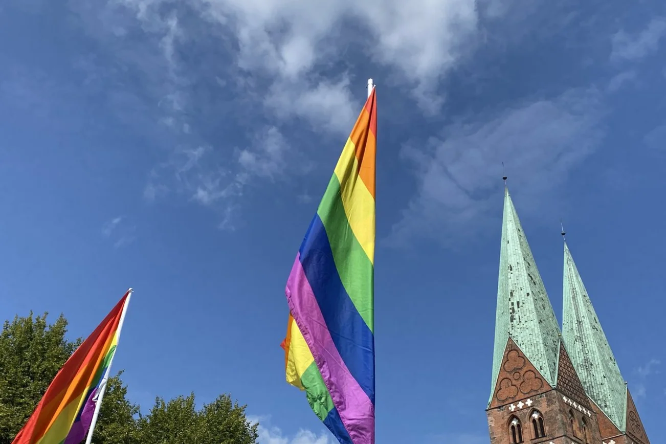 Eine Regenbogenflagge und ein Kirchturm
