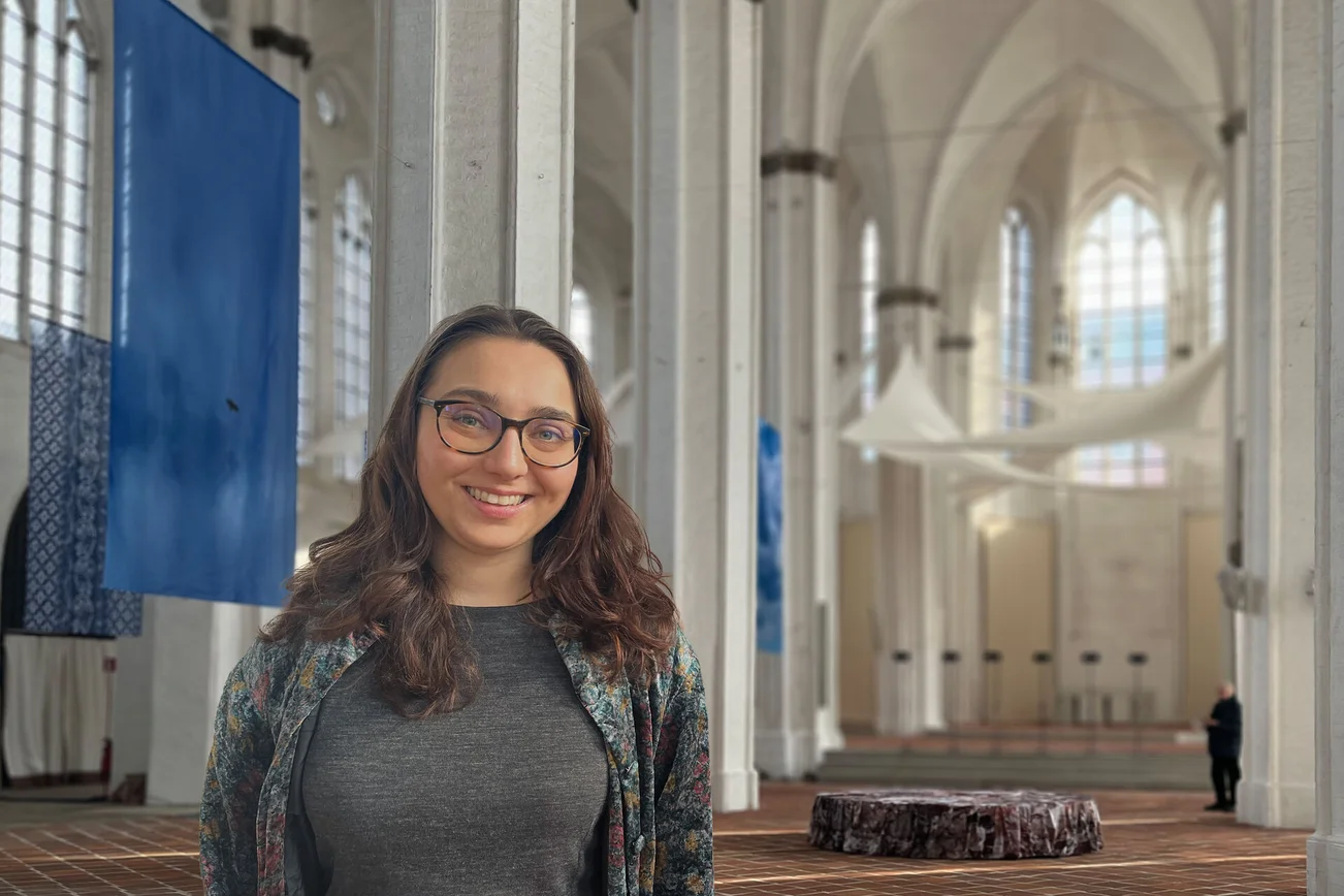 Eine Frau steht in einer Kirche 