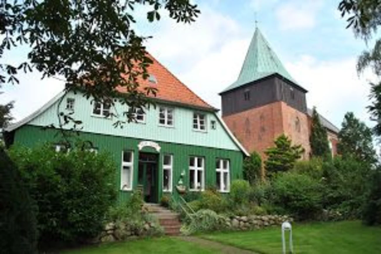 Fasade vom Pastorat in Krummesse mit dem Kirchturm im Hintergrund