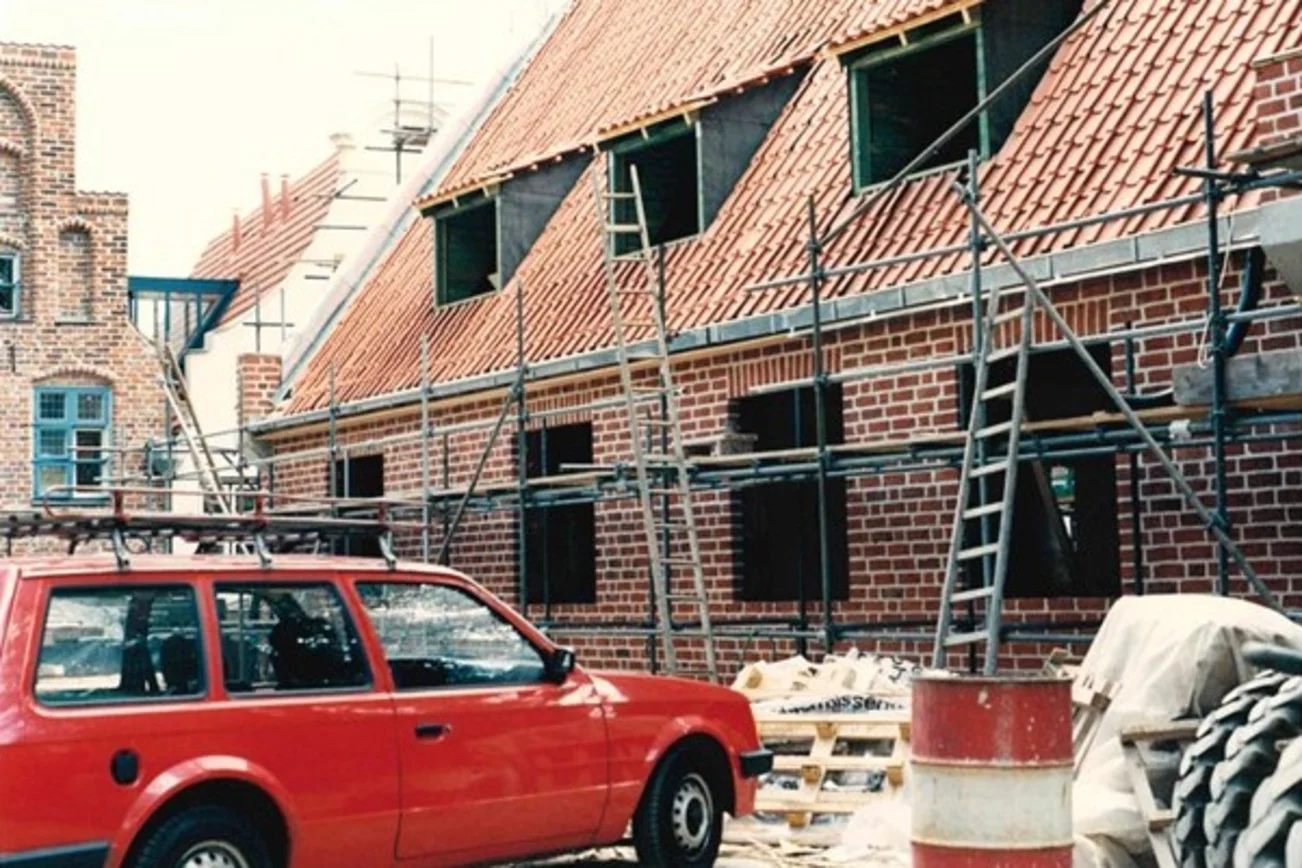 Ein Auto vor einem Backsteinhaus, das noch im Bau ist.